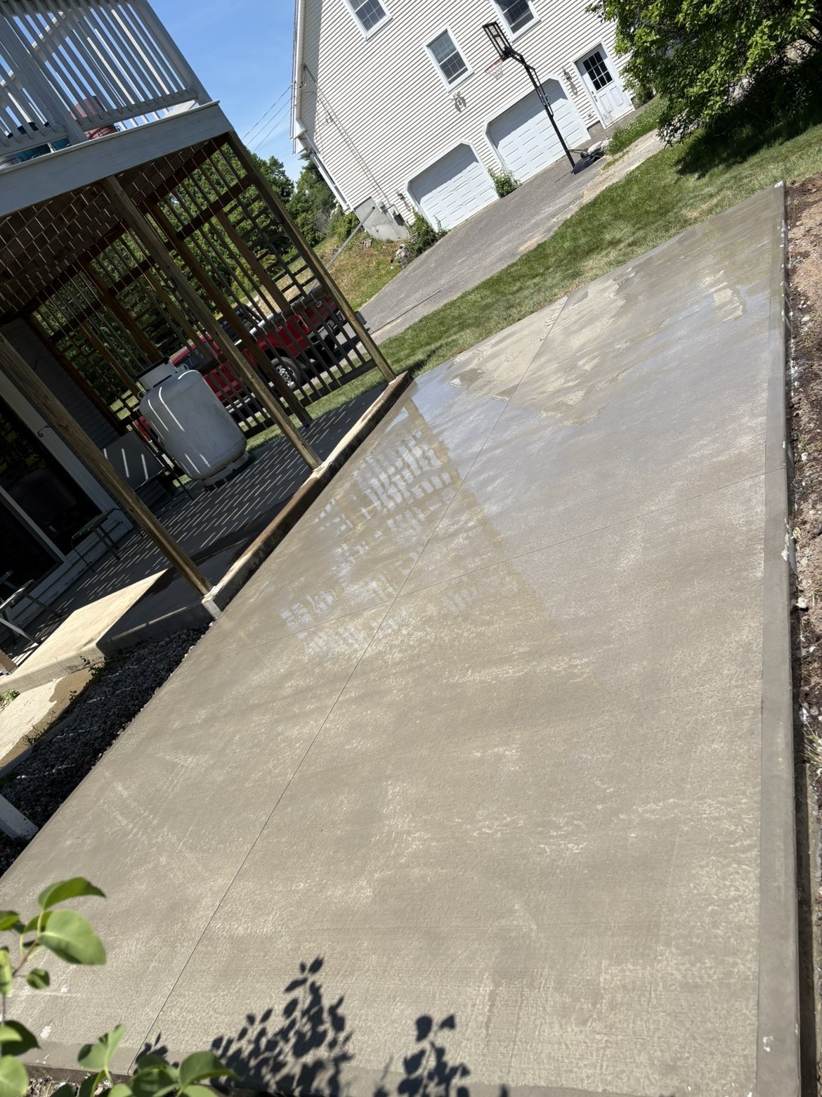 After: finished concrete patio beside a porch