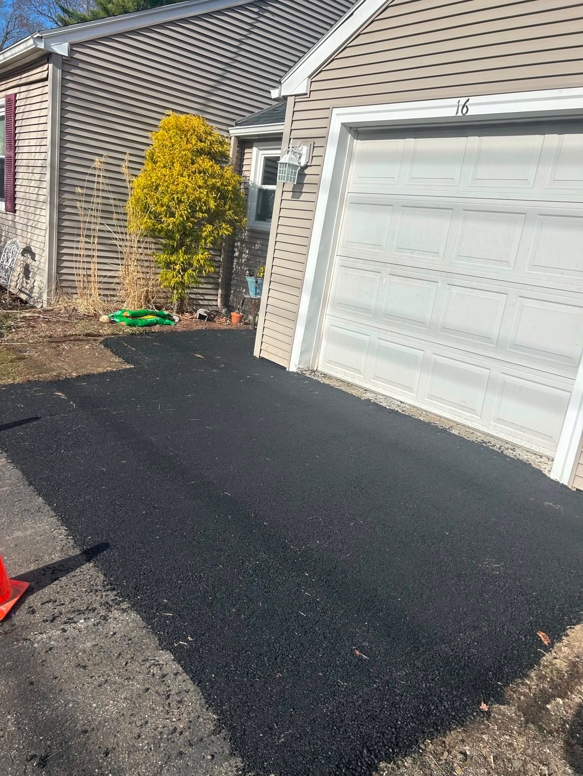 Asphalt patch beside a garage