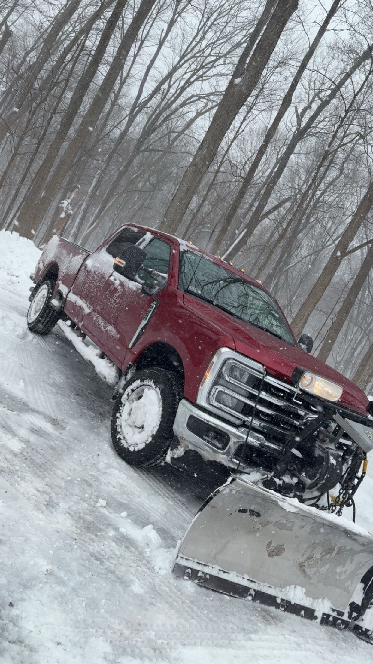 Red plow truck working in snowy conditions